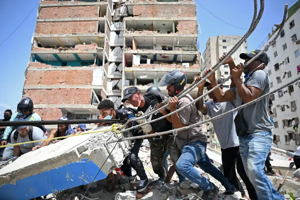 Voluntarios intentan retirar escombros mientras buscan cuerpos entre los restos de edificios colapsados ​​en Catia La Mar, La Guaira (Venezuela)
